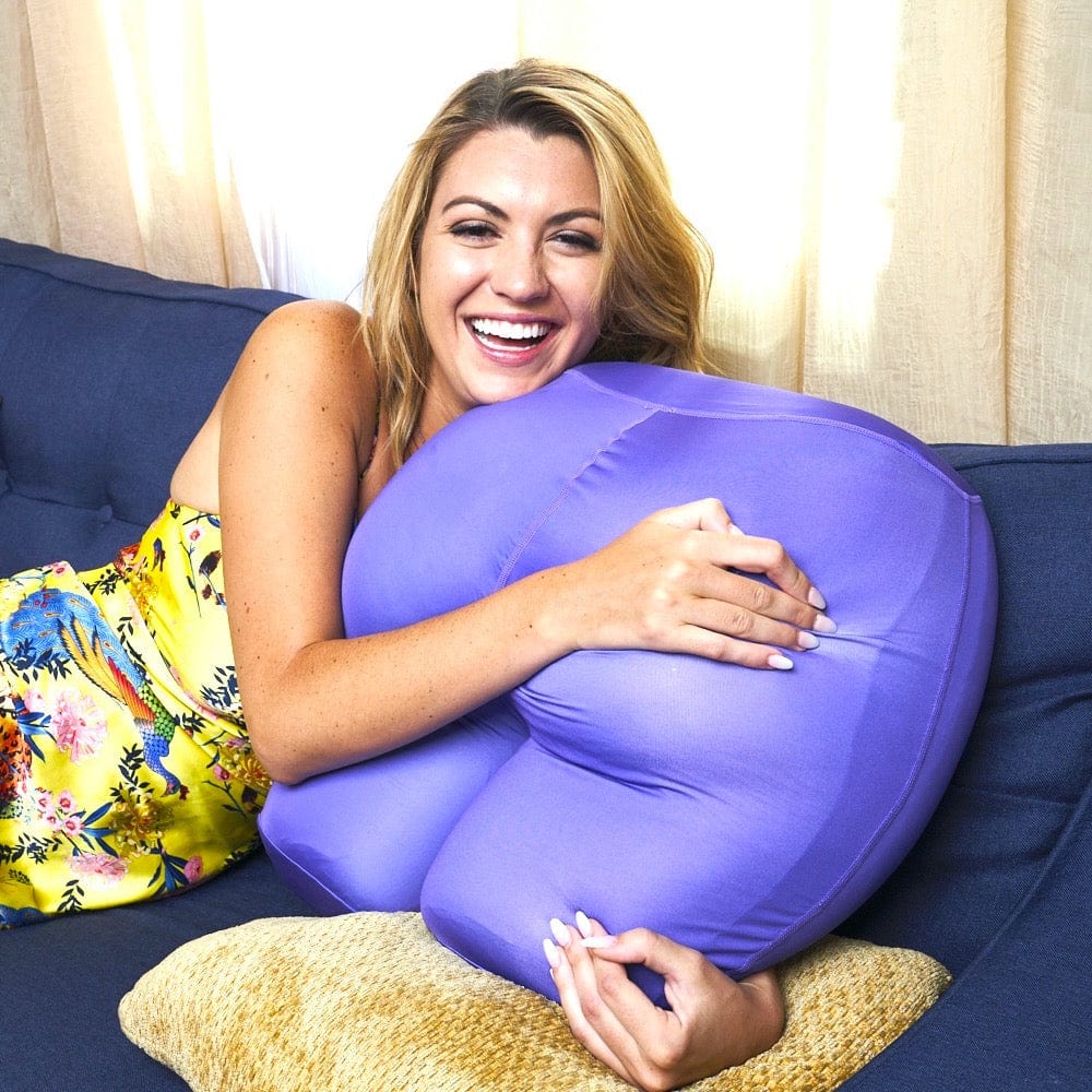 The OMG Size Buttress Pillow Happy Booty Pillow in Purple Lounge on Couch with Model